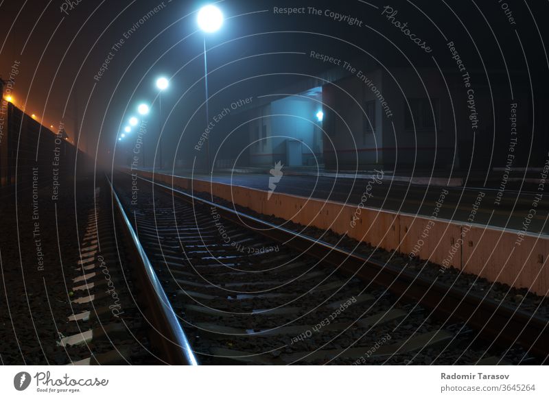 railway station at night railroad platform light track city modern urban industrial spotlight perspective europe metal line steel