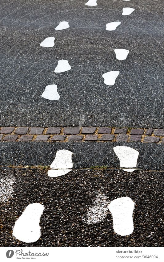 White footprints on the asphalt of the road footsteps Street Asphalt Exterior shot Deserted Signs and labeling Colour photo Transport Lanes & trails Gray