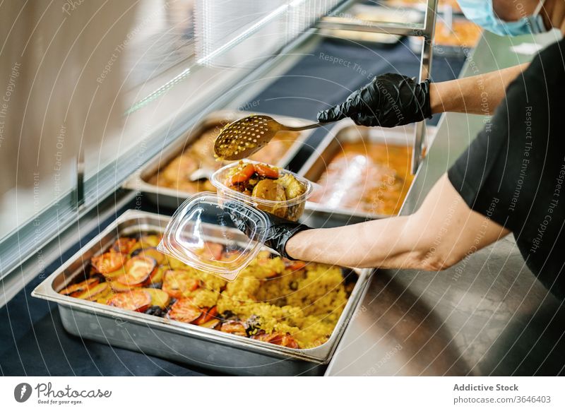 Crop cafe worker packing food in plastic container for takeaway waitress respirator coronavirus tasty busy glove concentrate woman cuisine service yummy