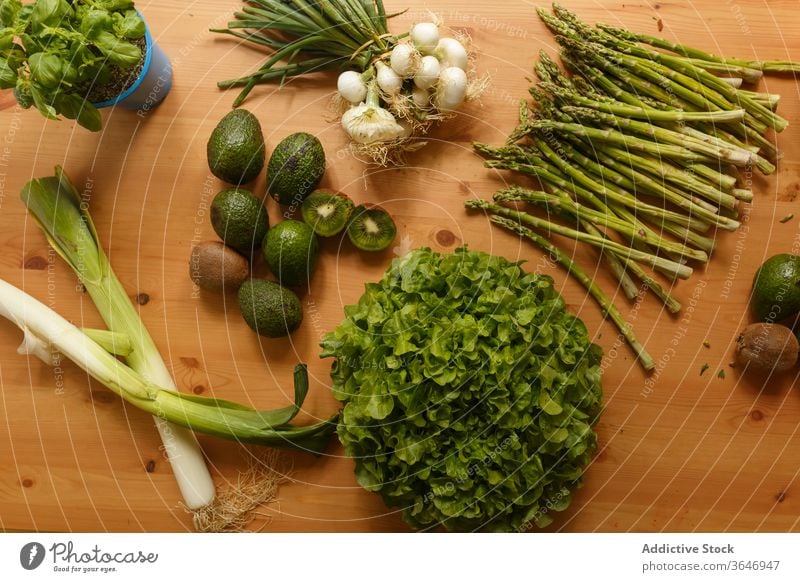 Green vegetables on wooden table green grocery various assorted greenery tasty healthy vegetarian organic basil leek asparagus lettuce onion avocado kitchen