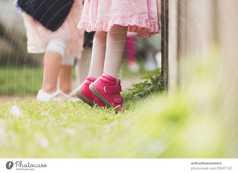 Child stands on tiptoe in front of a fence children Infancy wax girl people Growth come of age Playing Curiosity Small Nature Summer Joy high up youthful