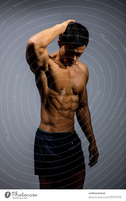 Asian Fitness Model Flexes Muscular Abdomen Nam Vo fitness model male muscular muscles strength sport athletic studio shot human body physique torso shirtless