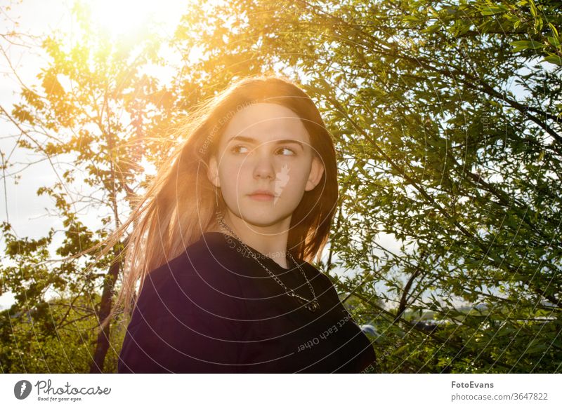 Girl is standing outdoors with  tree and sundown portrait nature Person day beauty female attractive girl real real person hair bald sunrise soft modern evening