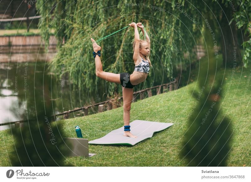 A teenage girl plays sports games near her home during quarantine self-isolation. Playing sports. Healthy lifestyle yoga outdoors mother daughter home workout