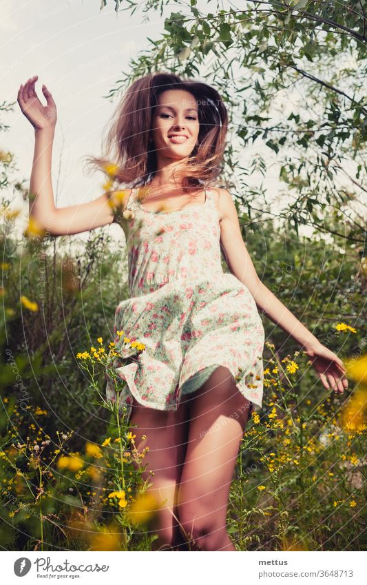 Happy girl. Blond haired woman dancing in the tall grass in the summertime ecstatically happy legs dance part of body dress jump active female young beauty