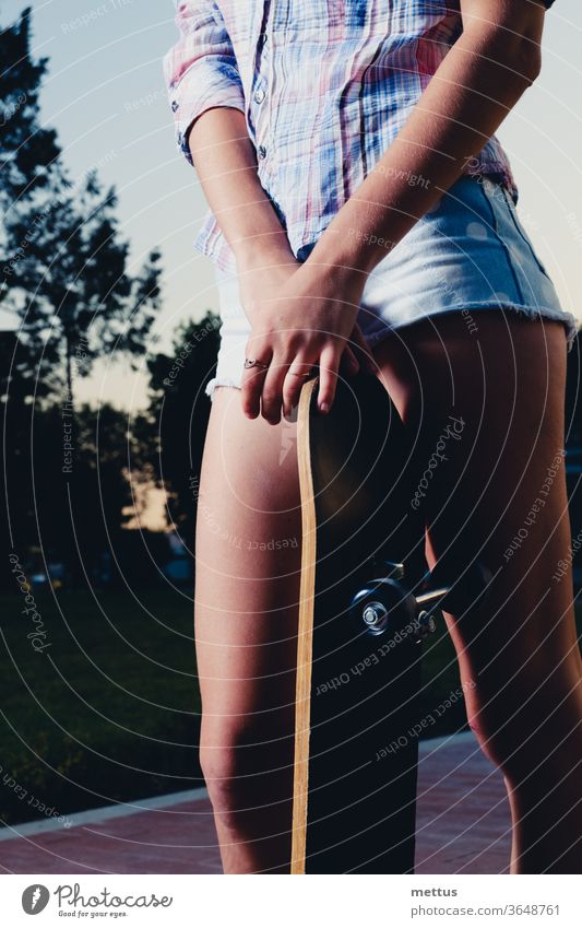 Low angle closeup of girl legs with skateboard fun woman female young youth sport active skateboarding skater people hair beautiful beauty casual happy pretty