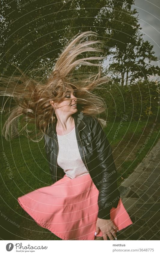 Woman dancing joyfully in the park lane in the evening time shake head non-stereotypical girlish city park copyspace woman happy dance dynamic movement