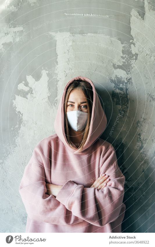 Woman in sterile mask standing near wall during quarantine period woman self isolation discontent coronavirus at home concrete domestic social distancing casual