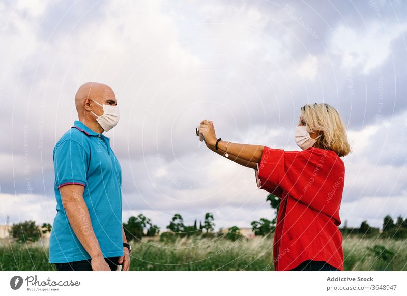 Woman taking photo of husband in nature couple take photo photo camera mask summer content covid 19 moment photography hobby together memory capture using