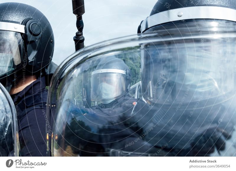 Professional policemen in protective gear during dangerous operation swat fight assault rifle shield equipment uniform partner helmet security weapon service