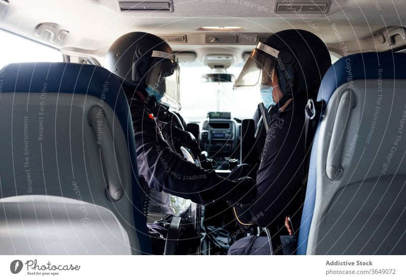 Police officers in squad car during service men set police equipment gear safety protect professional uniform partner medical mask speak vehicle transport job