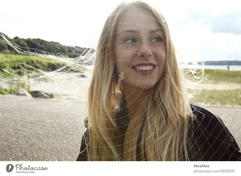 Backlit portrait of a young, blond, smiling woman at the sea Woman Young woman Blonde already Slim Long-haired windy Esthetic Summer Trip Beautiful weather