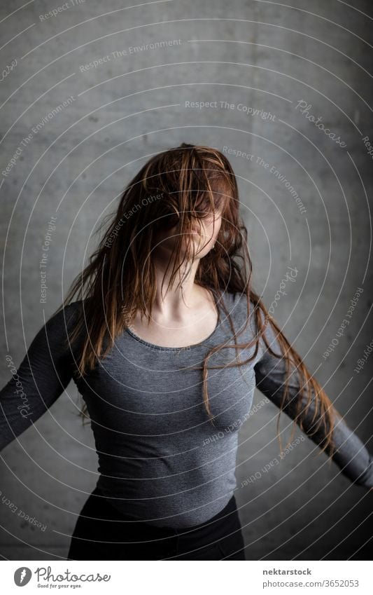 Young Woman With Hair Fallen on Face female one person girl hair in face hairstyle obscured face portrait young woman arms spread wild hair caucasian ethnicity