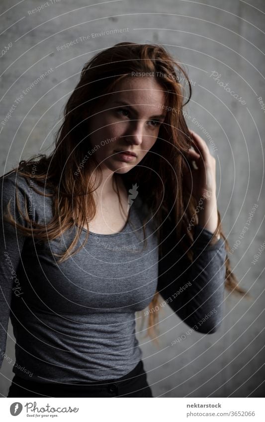 Young Woman Touching Hair and Looking Away female one person girl portrait hairstyle contemplation state of mind looking away young woman caucasian ethnicity