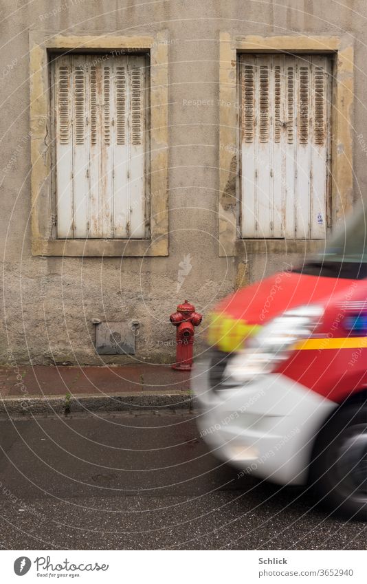 House facade in Lorraine Metz with hydrant in rainy weather Emergency ambulance races into the picture House (Residential Structure) Facade Window Ambulance