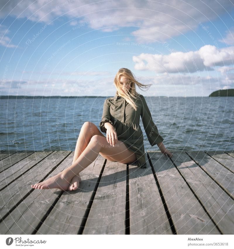 analogue full body portrait of a young, blond, barefoot woman on a wooden jetty in the sea Woman Young woman Blonde already Slim Long-haired windy Esthetic