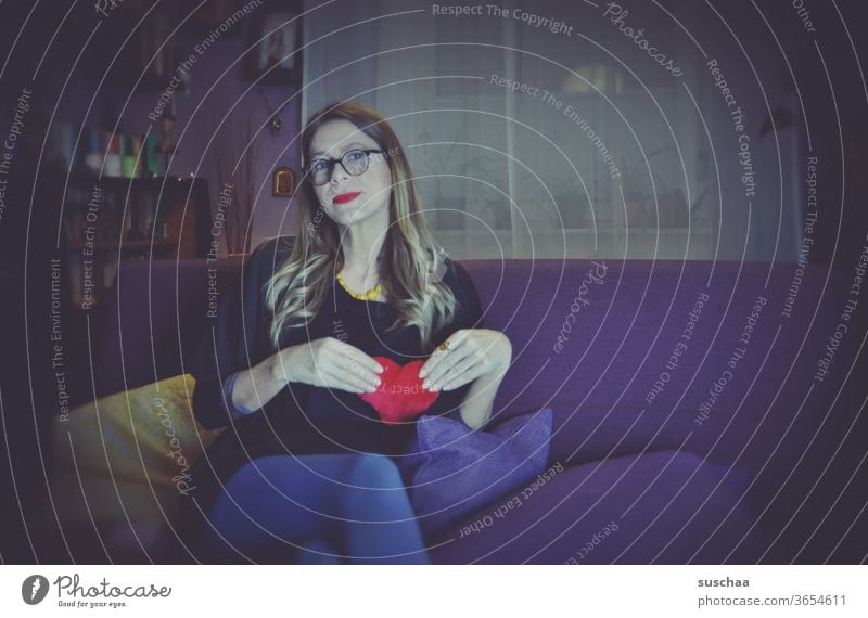 woman with red lips on a sofa holding a red fabric heart in front of her breast Woman Sofa Living room Lonely by oneself Love Loneliness Head Quarantine