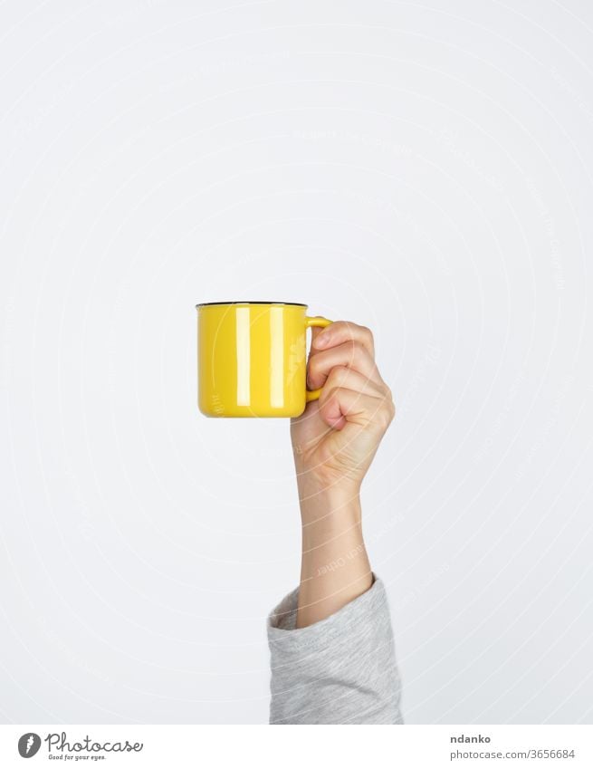 yellow ceramic cup in a female hand on a white background coffee coffee break container design drink espresso finger food hold hot kitchen left lunch mug one