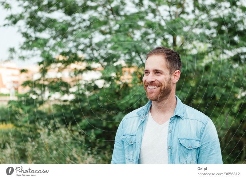 Portrait of a casual men in a park male young handsome man model guy beard fashion portrait denim attractive people adult person confident style enjoy shirt