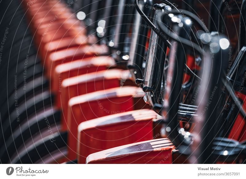 Abstract detail of a series of modern rental bikes parked on a street in the city Bicycle Parking Rent Modern City Street Row sunny during the day urban