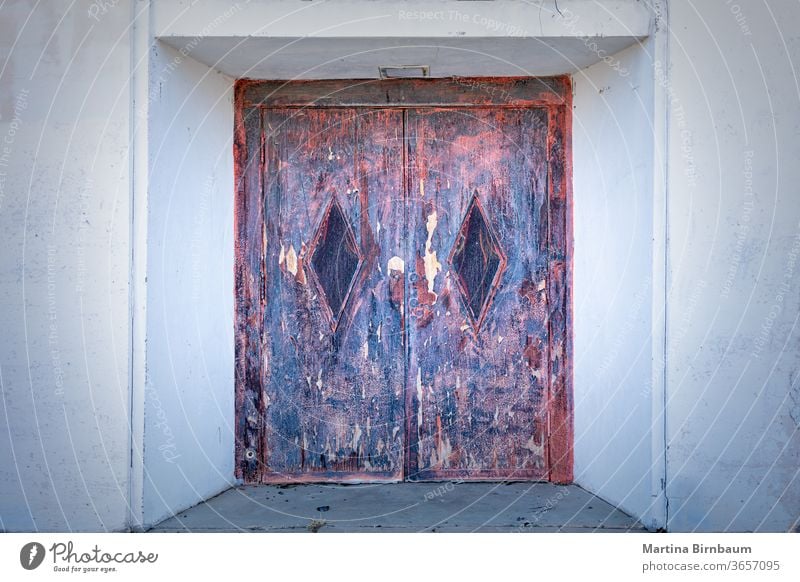 Old and rusty door, entrance to an old abandoned building metal red wall iron spot vintage background material metallic weathered brown abstract scratch texture