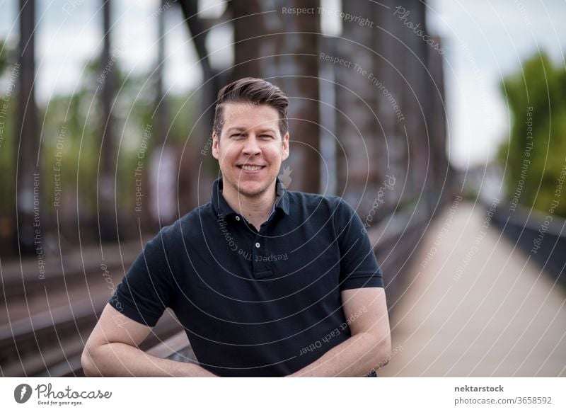 Portrait of a Handsome Man Posing on a City Bridge bridge adult caucasian city posing portrait standing balustrade selective focus one person urban handsome