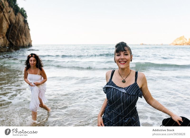 Happy women running on foamy sea near shore beach vacation friend tourism fun barefoot entertain girlfriend harmony ocean together mount partner pleasure hat