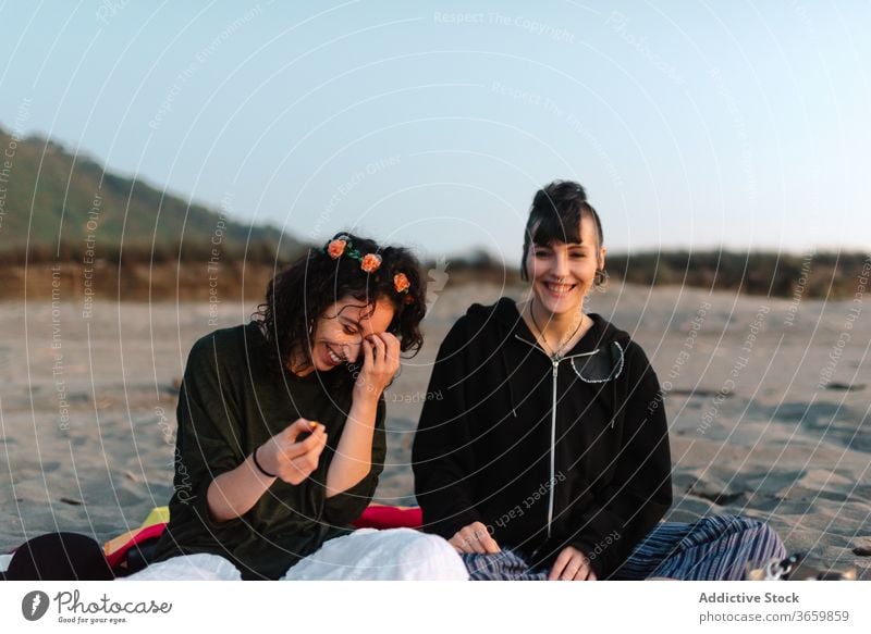 Cheerful girlfriends spending time together on sandy beach in daylight relax tourism couple spend time laugh eyes closed harmony sensual love satisfied positive