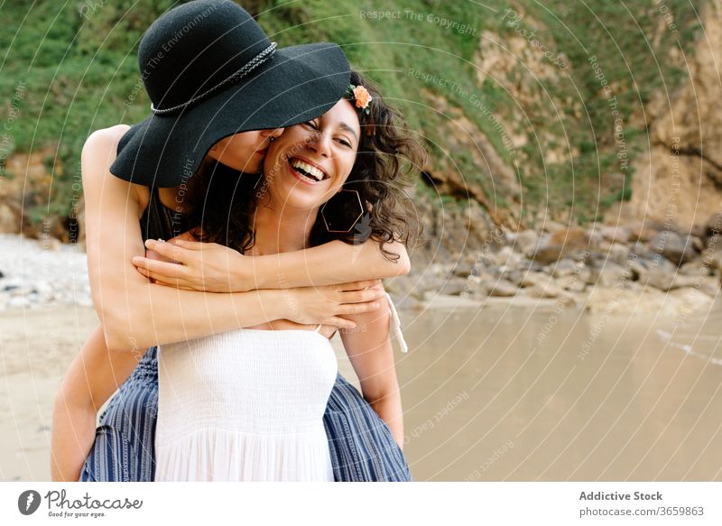 Lesbian couple embracing near ocean during honeymoon in summer girlfriend women romantic embrace walk shore idyllic harmony together vacation weekend lgbt