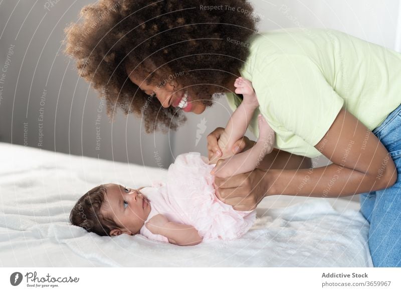 Content ethnic mother playing with baby infant woman tender newborn adorable content having fun home female african american black cheerful parent kid child