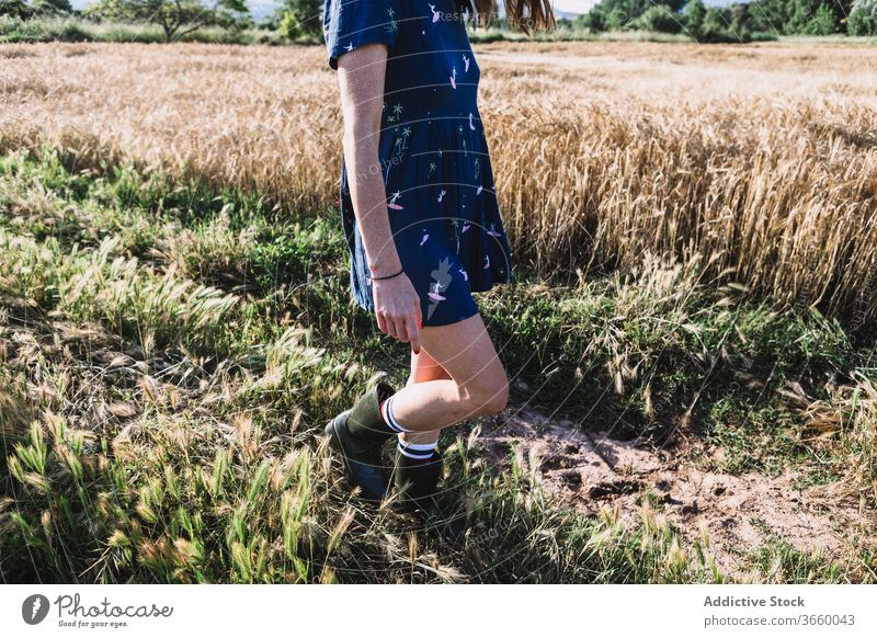 Cheerful woman walking along field run countryside carefree weekend summer sunny freedom cheerful female rubber boot dress joy meadow nature harmony idyllic