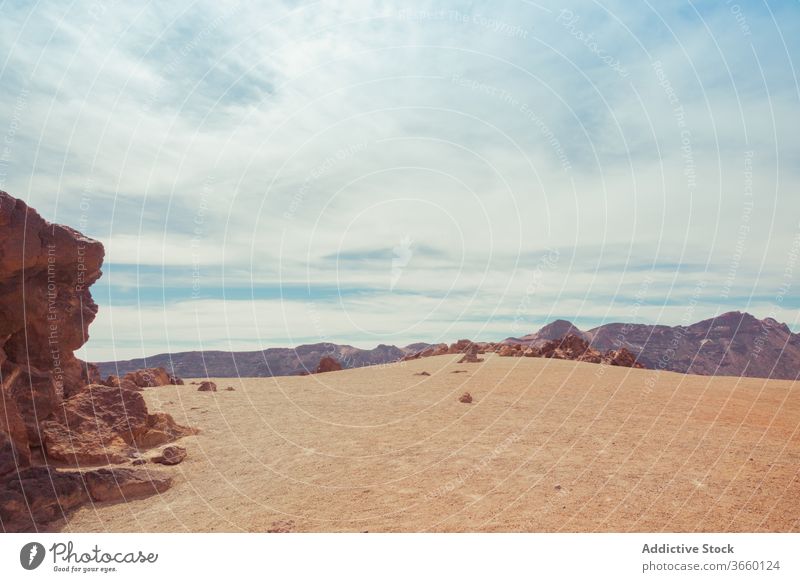 Rocks near bushes under spectacular blue sky with clouds rock desert nature highland picturesque idyllic harmony scenery mount cloudy paradise small green shrub