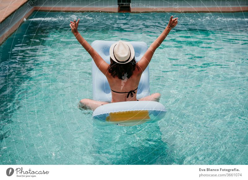 happy woman on inflatable having fun. Summer time. back view swimming pool summer blue water relax hat sexy lifestyle sunglasses swimwear hot body tanning spa