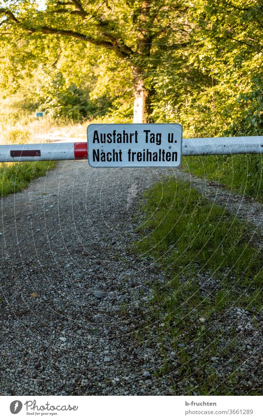 Barriers with sign "Keep exit clear day and night", forest road, nature off Signs and labeling Highway ramp (exit) lock block cordon Street Signage Warning sign