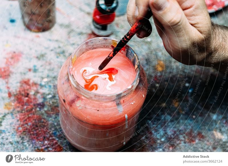 Crop artist washing paintbrush off in jar with painted water clean artwork studio pigment color occupation profession hand watercolor painter wet professional