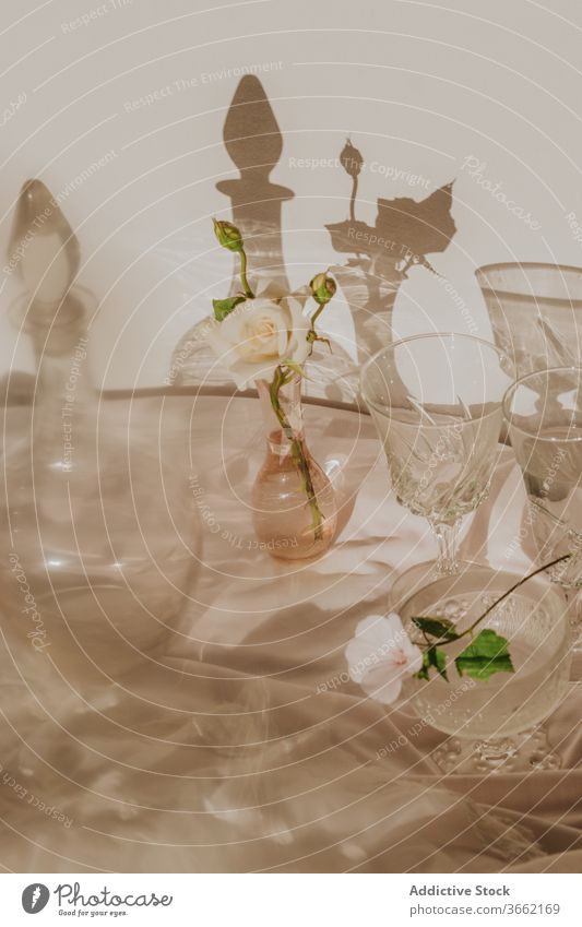 Elegant table decoration with glassware and fragrant white flowers vase decanter elegant delicate composition shadow design vintage classic feminine bloom