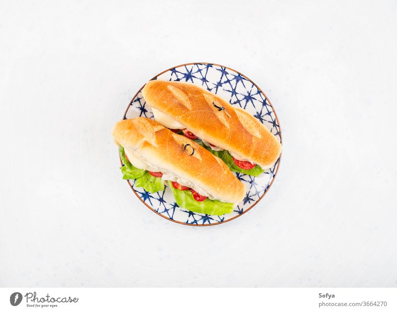 Baguette sandwich with tomatoes and cheese baguette submarine bread lunch hoagie flat lay melted vegetable top view salad lettuce wooden food white board napkin