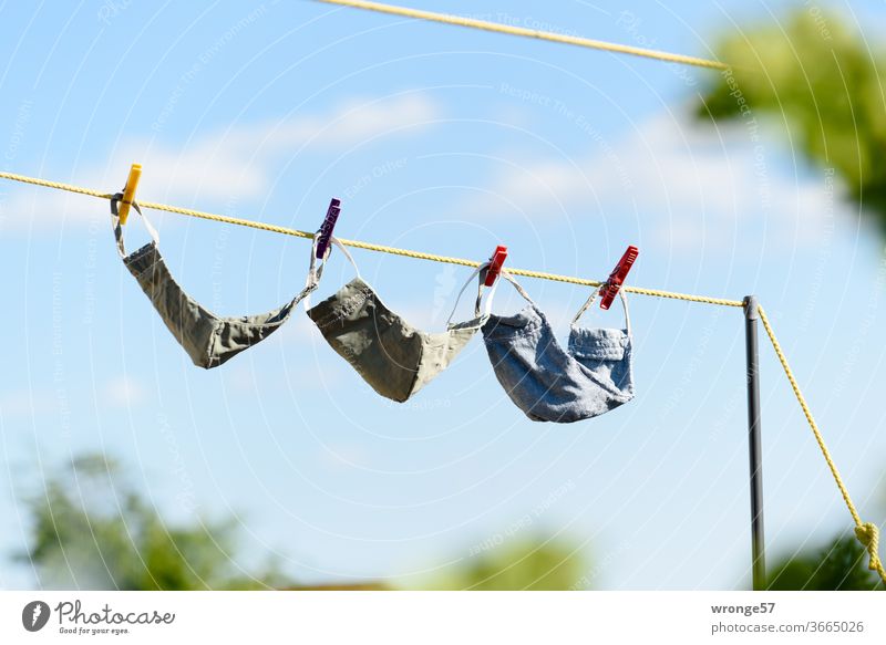 Freshly washed 3 self-sewn masks hang on the clothesline to dry Mask Mouth protection mask 3 pieces freshly laundered Self-made Dry Clothesline Laundered