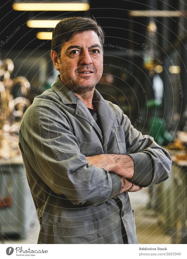 Portrait of craftsman standing in workshop handicraft happy uniform small business studio art gold goldsmith workspace solid artwork workplace calm metal