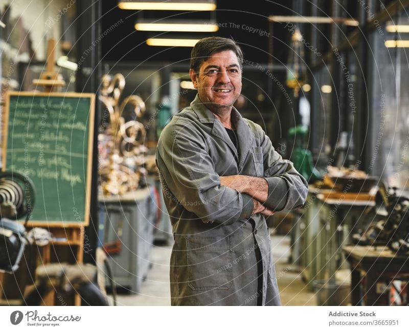 Portrait of craftsman standing in workshop handicraft happy uniform small business studio art gold goldsmith workspace solid artwork workplace calm metal