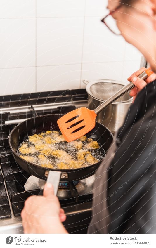 Anonymous chef frying artichokes in kitchen. food gourmet dish cooking meal cuisine fresh restaurant tasty dinner recipe delicious vegetable healthy cooked