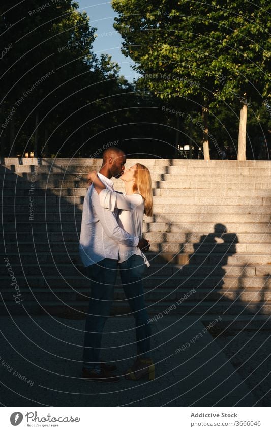 Diverse couple hugging and kissing on street bonding romantic content relationship eyes closed urban love madrid spain happy affection embrace modern casual