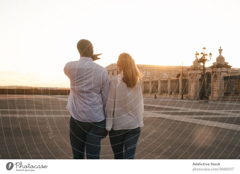 Romantic multiethnic couple holding hands and strolling along city street walk romantic carefree relationship fondness harmony affection casual spain madrid