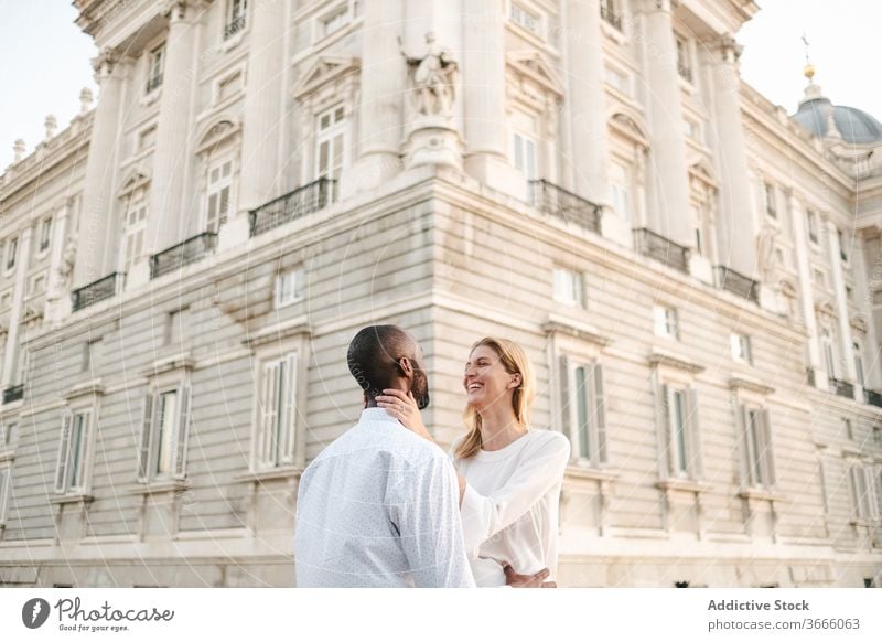 Positive multiethnic couple embracing on street bonding embrace positive candid love content madrid affection gentle casual lifestyle spain sunlight enjoy