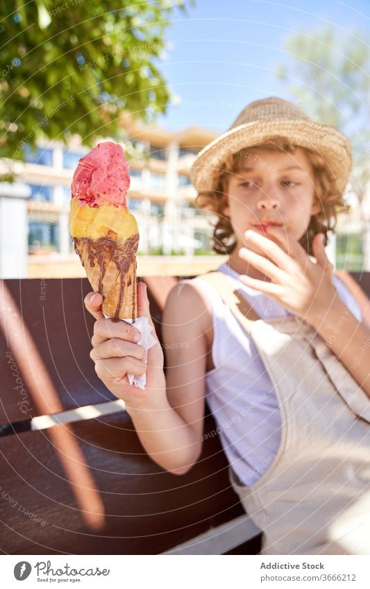 Delighted boy with tasty ice cream cone melt pleasure glad weekend vacation summertime dessert nature treat child delicious food yummy childhood street carefree