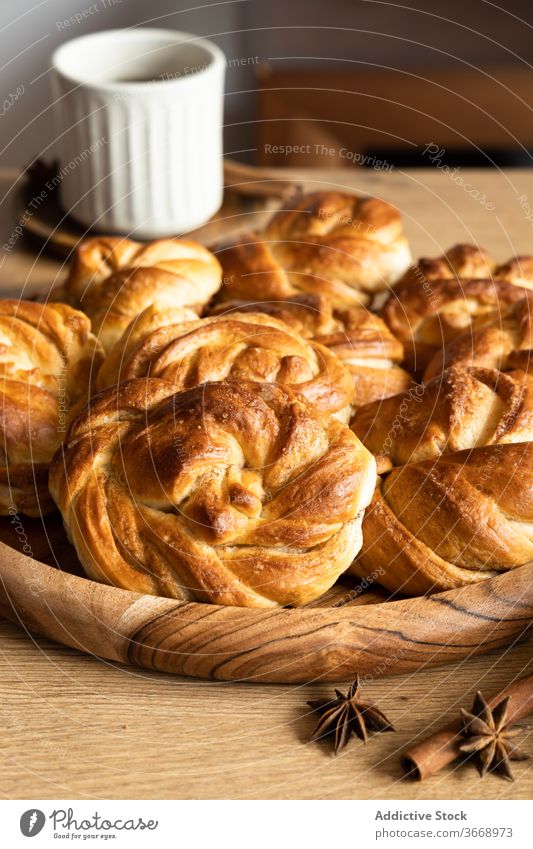 Pile of delicious cinnamon buns on table roll pile tasty kitchen morning breakfast homemade coffee cup wooden food stack fresh drink yummy gourmet hot tradition