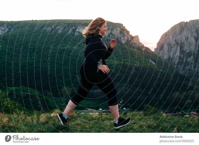 Sportswoman jogging in mountains during sunset run evening highland plump sportswoman training female transylvania romania saint george green sportswear nature