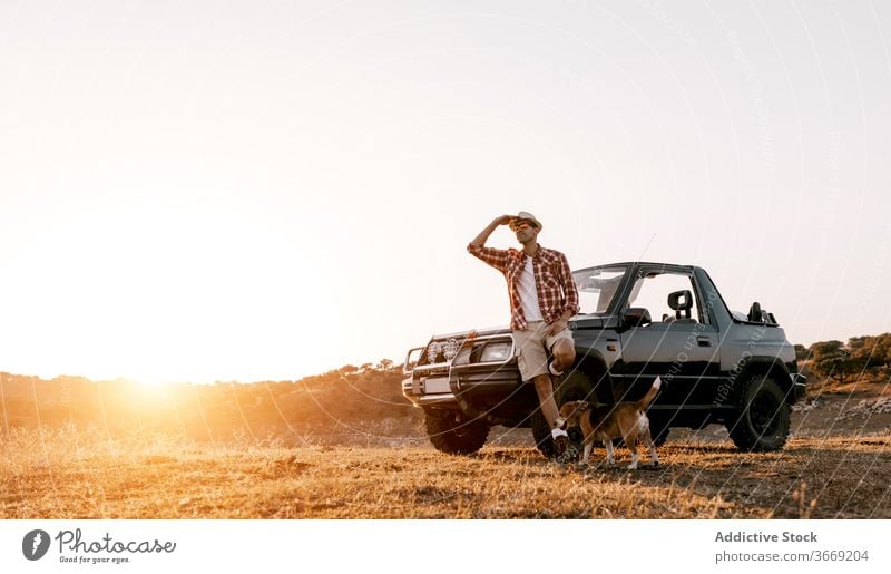 Tourist with backpack standing near dog and car admiring nature tourist contemplate highland travel automobile river mountain idyllic harmony picturesque