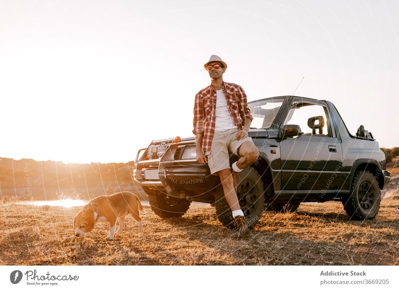 Tourist with backpack standing near dog and car admiring nature tourist contemplate highland travel automobile river mountain idyllic harmony picturesque