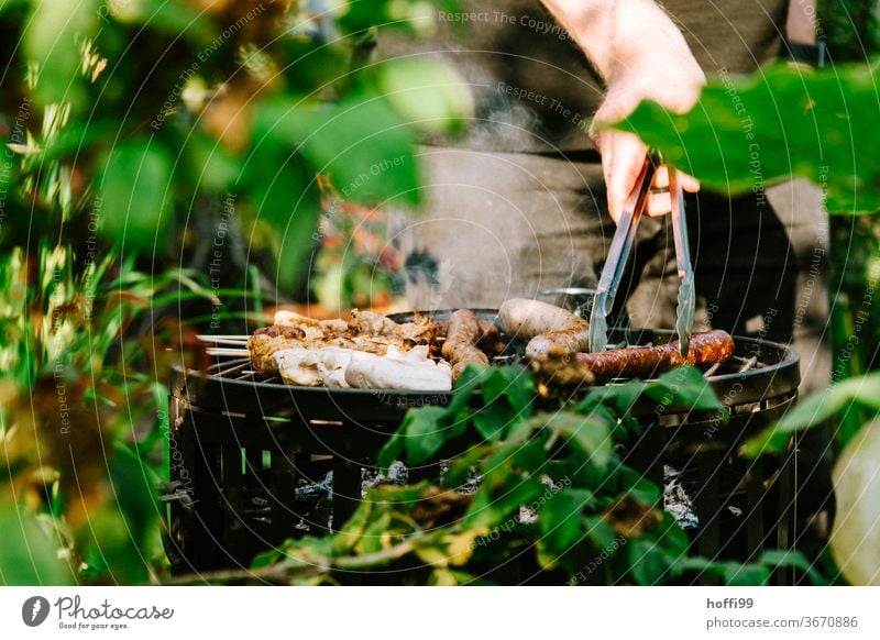 Please turn - the sausage on the grill is turned BBQ by hand barbecue tongs charcoal grill Small sausage barbecue food grilled meat Barbecue (apparatus)